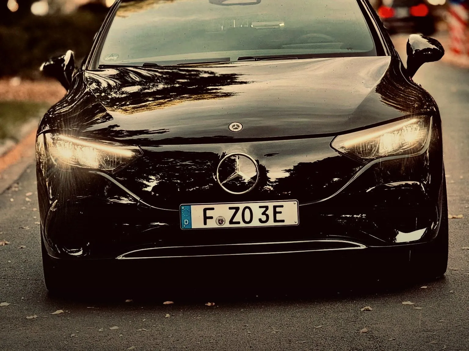 Schwarzer Mercedes-Benz EQE 300 von vorn auf einer Allee in Frankfurt